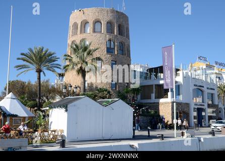 Marbella, Espagne - 10 décembre 2023 : les gens à côté de la tour de guet de la marina Banus à Marbella, Andalousie, Espagne. Banque D'Images