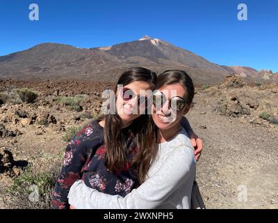 Deux femmes embrassent dans le désert avec des montagnes en arrière-plan Banque D'Images