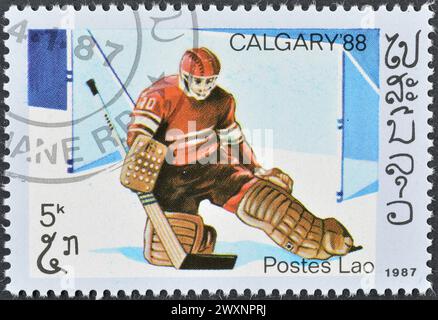 Timbre-poste oblitéré imprimé par le Laos, qui fait la promotion des Jeux olympiques d'hiver à Calgary, vers 1987. Banque D'Images