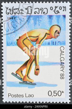 Timbre-poste oblitéré imprimé par le Laos, qui fait la promotion des Jeux olympiques d'hiver à Calgary, vers 1987. Banque D'Images