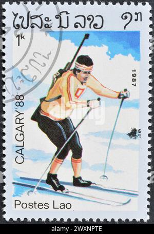 Timbre-poste oblitéré imprimé par le Laos, qui fait la promotion des Jeux olympiques d'hiver à Calgary, vers 1987. Banque D'Images