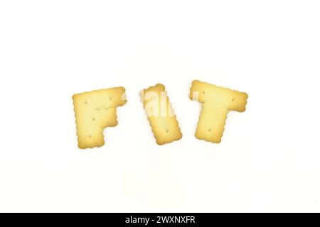 Biscuits en forme de lettre majuscule formant le mot FIT isolé sur fond blanc Banque D'Images