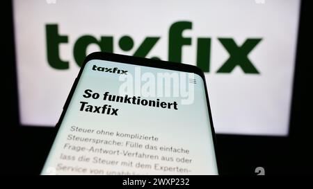 Téléphone portable avec le site Web de la société allemande de logiciels fiscaux Taxfix se devant le logo de l'entreprise. Concentrez-vous sur le coin supérieur gauche de l'écran du téléphone. Banque D'Images