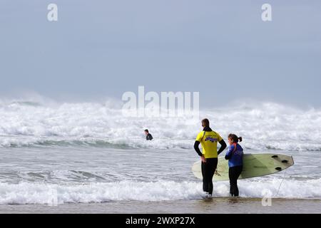 Cours de surf à Mawgan Porth, Cornwall, pendant un après-midi très venteux Banque D'Images