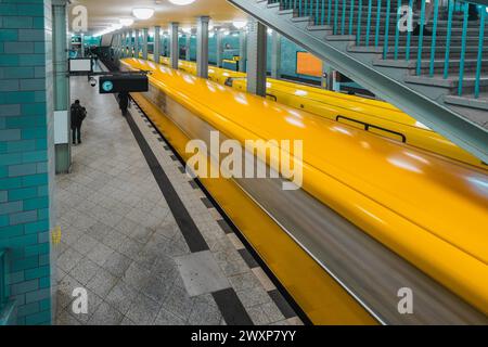 Métro ou station ubahn de Alexanderplatz à Berlin. Station de métro dans le cadre du système de métro berliner. Carreaux vintage verts et train jaune en moti Banque D'Images