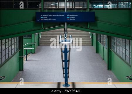 Station de train de style vintage de Messe South dans le réseau ferroviaire de banlieue de berlin. Escaliers menant aux plates-formes avec panneau d'information ci-dessus. Soirée se Banque D'Images