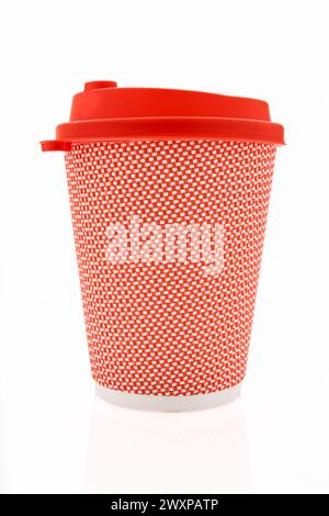 La tasse à café en carton rose avec un couvercle en plastique rouge sur le fond blanc brillant, l'inscription sur le couvercle est soigneusement chaud, transparent Banque D'Images
