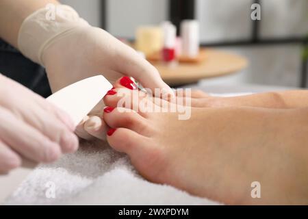 Pédicuriste classant les ongles des orteils du client dans un salon de beauté, gros plan Banque D'Images