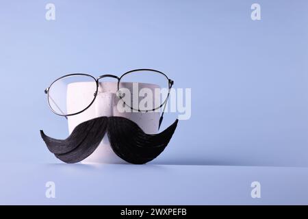 Visage de l'homme fait de moustache artificielle, lunettes et tasse sur fond bleu clair. Espace pour le texte Banque D'Images