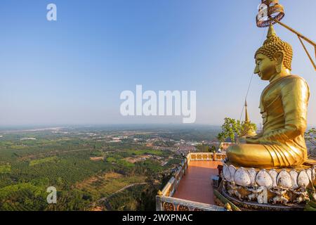 Vue panoramique de la région environnante et une grande statue dorée de Bouddha au sommet de la montagne au temple de la grotte du tigre (Wat Tham Suea) à Krabi, Thaïlande. Banque D'Images