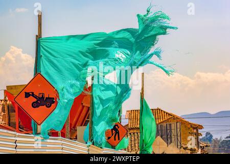 Un tissu d'ombre vert déchiré agité par le vent, dans un chantier de construction dans la ville coloniale de Villa de Leyva dans le centre de la Colombie. Banque D'Images