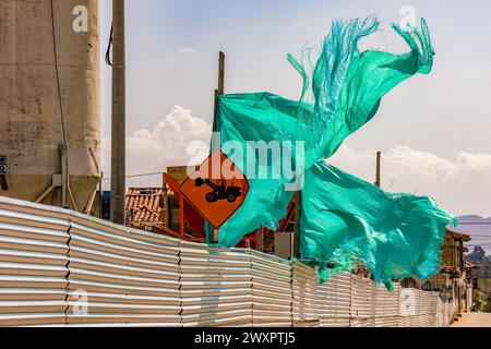 Un tissu d'ombre vert déchiré agité par le vent, dans un chantier de construction dans la ville coloniale de Villa de Leyva dans le centre de la Colombie. Banque D'Images