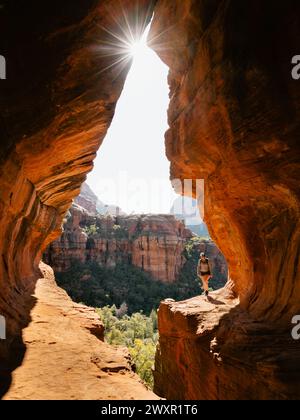 Lumière du soleil tôt le matin à secret Subway Cave Boynton Canyon Sedona avec femme randonneuse solo. Banque D'Images