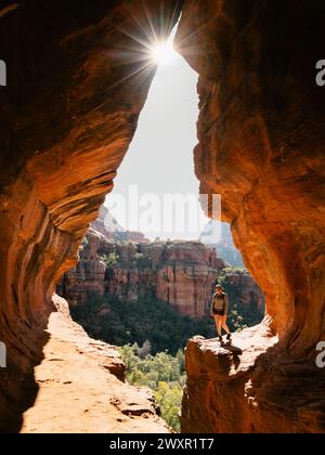 Lumière du soleil tôt le matin à secret Subway Cave Boynton Canyon Sedona avec femme solo trekker. Banque D'Images