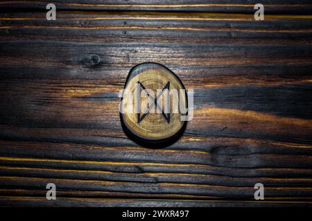 Rune Dagaz sculptée dans du bois sur un fond de bois - Elder Futhark Banque D'Images