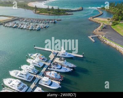Vue aérienne de bateaux dans une marina côtière et rivière qui coule vers l'océan à Bermagui en Nouvelle-Galles du Sud, Australie Banque D'Images