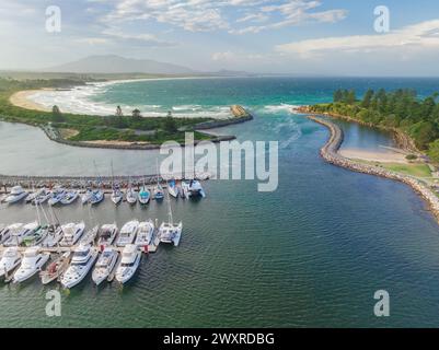 Vue aérienne de bateaux dans une marina côtière et rivière qui coule vers l'océan à Bermagui en Nouvelle-Galles du Sud, Australie Banque D'Images