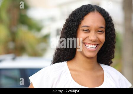 Portrait d'une femme noire heureuse avec le sourire parfait dans la rue Banque D'Images