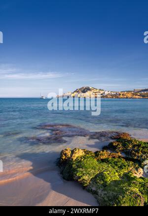 Une vue sur la baie idyllique et la plage de Cala Agulla dans l'est de Majorque avec un voilier au premier plan Banque D'Images