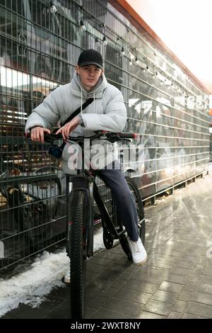 Concept de location de vélos. Un homme se promène dans la ville en hiver avec un vélo Banque D'Images