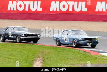 La Mustang de James Thorp (67) se battant contre la Mustang de Sir Chris Hoy (41) lors du trophée Adrian flux pour la course transatlantique pré '66 Touring Cars Race Banque D'Images