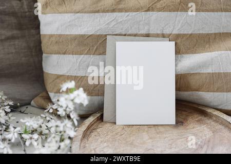 Composition pour natures mortes printanières. Maquette de carte de voeux vierge, enveloppe artisanale. Photo de style féminin. Scène florale. Fleurs de cerisier blanc floues sur Banque D'Images