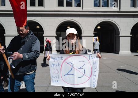 San Francisco, États-Unis. 24 mars 2024. Un jeune militant tient une pancarte en l'air, exhortant la communauté internationale à se tenir aux côtés de Hong Kong contre les lois oppressives de sécurité nationale de l'article 23. Dans une puissante démonstration de solidarité, les manifestants de San Francisco se sont rassemblés pour se rassembler contre la mise en œuvre de l'article 23 des lois sur la sécurité nationale à Hong Kong. La manifestation, qui s’est déroulée au cœur de la ville, a attiré une foule diversifiée d’activistes, d’étudiants et de citoyens concernés. (Photo de Chin Hei Leung/SOPA images/Sipa USA) crédit : Sipa USA/Alamy Live News Banque D'Images