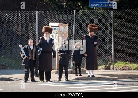 Le Pourim 2024, les Juifs orthodoxes d'âges divers rentrent chez eux après les services avec les hommes plus âgés portent des chapeaux de fourrure shtreimel. À Brooklyn, New York. Banque D'Images