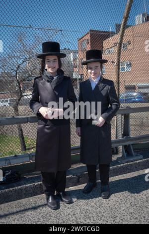 Portrait de 2 adolescents hassidiques qui ont passé les vacances de Pourim à collecter des fonds pour la charité. Sur le pont autoroutier Brooklyn Queens à Brooklyn NYC. Banque D'Images