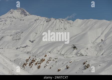 Hélicoptère dans les montagnes Kazbek. L'héliboard freeride dans le Caucase. Snowboard freeride en hiver. Heliboarding freeride. Rouler dans la poudreuse Banque D'Images