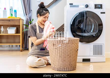 Une femme assise sur le sol, lavant le linge Banque D'Images