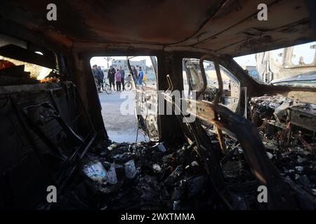 Rafah, Gaza. 02 avril 2024. Les gens se rassemblent autour de la carcasse d’une voiture utilisée par le groupe humanitaire américain World Central Kitchen, qui a été touchée par une frappe israélienne la veille à Deir al-Balah, dans le centre de la bande de Gaza, le mardi 2 avril 2024. L'organisation caritative internationale d'aide alimentaire a déclaré le 2 avril qu'elle suspendait ses opérations d'aide à Gaza après que sept de ses employés aient été tués dans une « frappe israélienne ciblée » alors qu'ils déchargeaient l'aide alimentaire dont ils avaient désespérément besoin livrée par la mer depuis Chypre. Photo de Ismael Mohamad/UPI crédit : UPI/Alamy Live News Banque D'Images