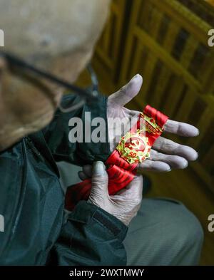 (240402) -- LHASSA, 2 avril 2024 (Xinhua) -- Yeshe Samdrup vérifie sa médaille commémorative décernée aux membres du Parti communiste chinois après 50 ans d'adhésion au Parti dans le district de Doilungdeqen à Lhassa, dans la région autonome de Xizang, au sud-ouest de la Chine, le 13 mars 2024. Yeshe Samdrup est né en 1936. Quand il se souvient de ses souvenirs d'enfance, il se souvient de l'expérience comme il a recueilli le combustible sec de bouse pour le propriétaire de serf et n'a reçu qu'un peu de nourriture comme paiement. Il était presque impossible d'avoir de la viande comme nourriture à cette époque. "Comme le propriétaire du serf jette des os, nous devons nous battre avec des chiens pour le marro Banque D'Images