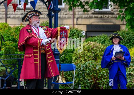 Crier de ville masculine (uniforme tressé coloré de crier) proclamant, faisant une proclamation publique forte et annonce - Ilkley, West Yorkshire, Angleterre Royaume-Uni. Banque D'Images