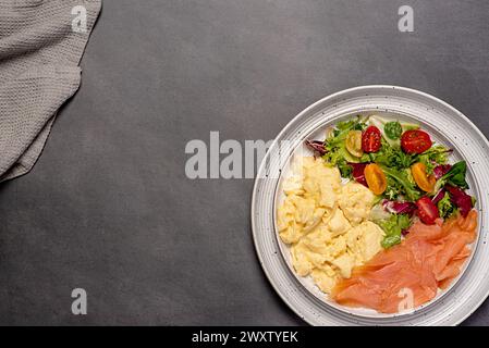 Photographie de nourriture vierge d'oeuf brouillé ; saumon fumé ; petit déjeuner ; brunch ; omelette; salade, tomate, laitue, régime céto, fond Banque D'Images