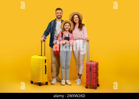 Famille prête pour les vacances avec des bagages sur fond jaune Banque D'Images