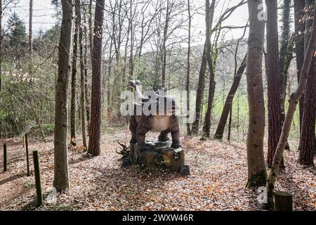 Une grande réplique de dinosaure dans la nature, dans une forêt Banque D'Images