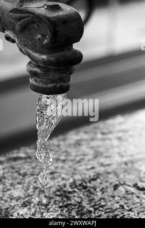 Gros plan de l'eau qui coule d'un robinet de jardin vintage. Banque D'Images