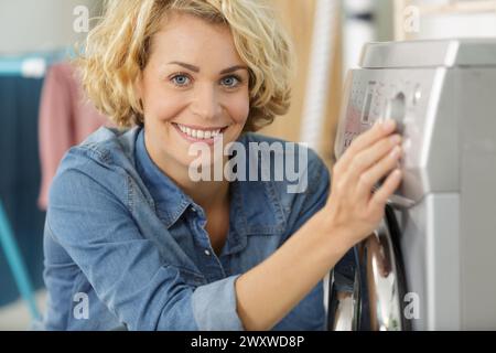 femme main choisissant le programme pour machine à laver Banque D'Images