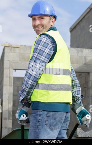 constructeur portant des blocs sur une brouette Banque D'Images