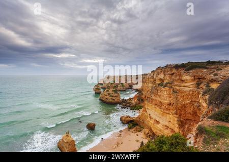 Paysage sur la côte de l'Algarve au coucher du soleil. Plage dans le sud du Portugal la meilleure destination de voyage pour les touristes en vacances. seascape avec des grottes à travers Banque D'Images