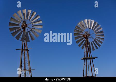 Section de turbine de deux moulins à vent de style ancien avec le ciel bleu comme arrière-plan. arrière-plan. Banque D'Images