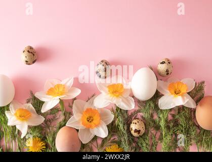 Arrangement créatif fait de fleurs de printemps, œufs, radis et aneth sur base rose pastel. Concept minimal de pâques. Pose à plat. Banque D'Images