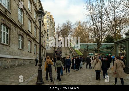 Paris, France - 17 février 2024 : vue panoramique des touristes qui montent et descendent les escaliers pittoresques à côté d'un funiculaire de Montmartre Paris Banque D'Images