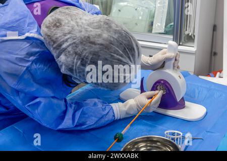 Outil jetable de sertissage de valvule cardiaque. Dans la salle d'opération, le médecin prépare la valve cardiaque pour la transplantation au patient porteur d'une valve cardiaque Banque D'Images