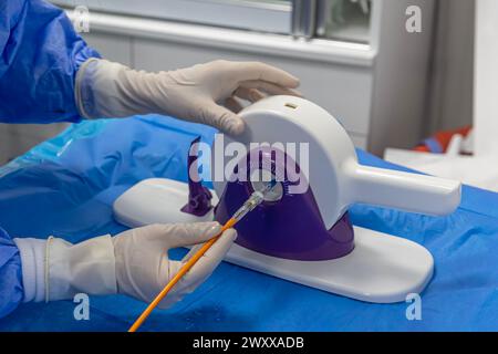 Outil jetable de sertissage de valvule cardiaque. Dans la salle d'opération, le médecin prépare la valve cardiaque pour la transplantation au patient porteur d'une valve cardiaque Banque D'Images