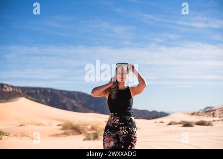 Femme marchant sur une dune de sable dans le désert à Coral Pink Sand Dunes State Park, Utah Banque D'Images