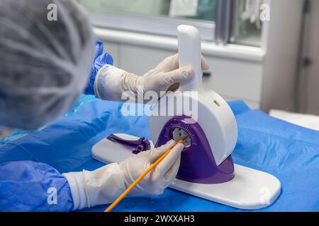 Outil jetable de sertissage de valvule cardiaque. Dans la salle d'opération, le médecin prépare la valve cardiaque pour la transplantation au patient porteur d'une valve cardiaque Banque D'Images