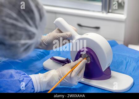 Outil jetable de sertissage de valvule cardiaque. Dans la salle d'opération, le médecin prépare la valve cardiaque pour la transplantation au patient porteur d'une valve cardiaque Banque D'Images