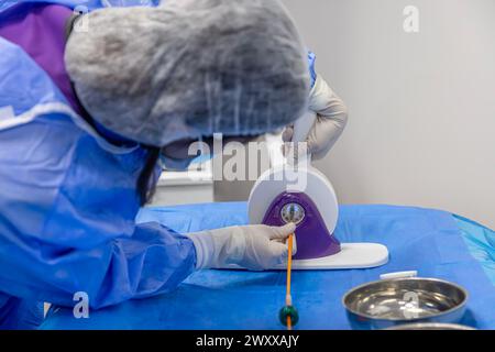 Outil jetable de sertissage de valvule cardiaque. Dans la salle d'opération, le médecin prépare la valve cardiaque pour la transplantation au patient porteur d'une valve cardiaque Banque D'Images